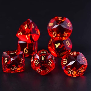 May include: Set of six red gemstone dice with gold numbering. The dice are various shapes, including a d4, d6, d8, d10, d12, and d20. The dice are displayed on a black surface.