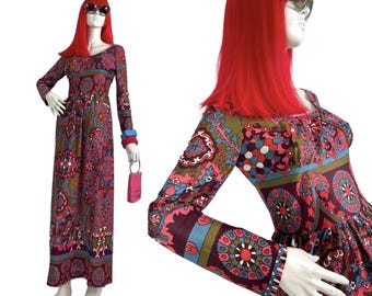 May include: A long-sleeved maxi dress with a colorful paisley print in shades of pink, blue, green, and brown. The dress has a fitted bodice and a flowing skirt.