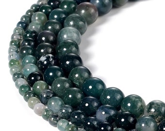 May include: A strand of green agate beads, with varying shades of green and white, arranged in a circle on a white background.