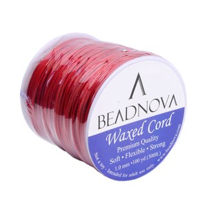 May include: A spool of red waxed cord, 100 yards (300 feet) long, with a label that reads "BEADNOVA Waxed Cord Premium Quality Soft Flexible Strong 1.0 mm - 100 yd (300ft.) Not a toy - Intended for adult use only. www.beadnova.com"