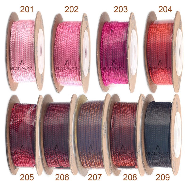 Puede incluir: Nueve carretes de cord&oacute;n, cada uno enrollado en un carrete de cart&oacute;n marr&oacute;n. Los cordones son de varios tonos de rosa, rojo, marr&oacute;n y negro. Los carretes est&aacute;n etiquetados con los n&uacute;meros del 201 al 209.