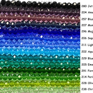 May include: Strands of faceted crystal beads in a gradient of colors, including black, purple, blue, and green. The image includes text labels for each color, such as "Jet," "Amethyst," and "Emerald."