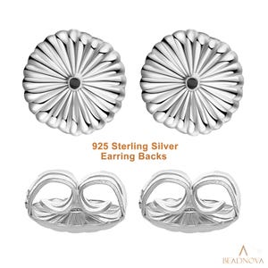 May include: Four sterling silver earring backs are shown. The backs are round with a ridged design, and the text "925 Sterling Silver Earring Backs" is printed below the earrings. These backs are designed to secure earrings.