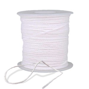 May include: A spool of white cotton cord, wound tightly on a plastic spool. The cord is about 1/8 inch thick and is ideal for crafts, jewelry making, and other projects.