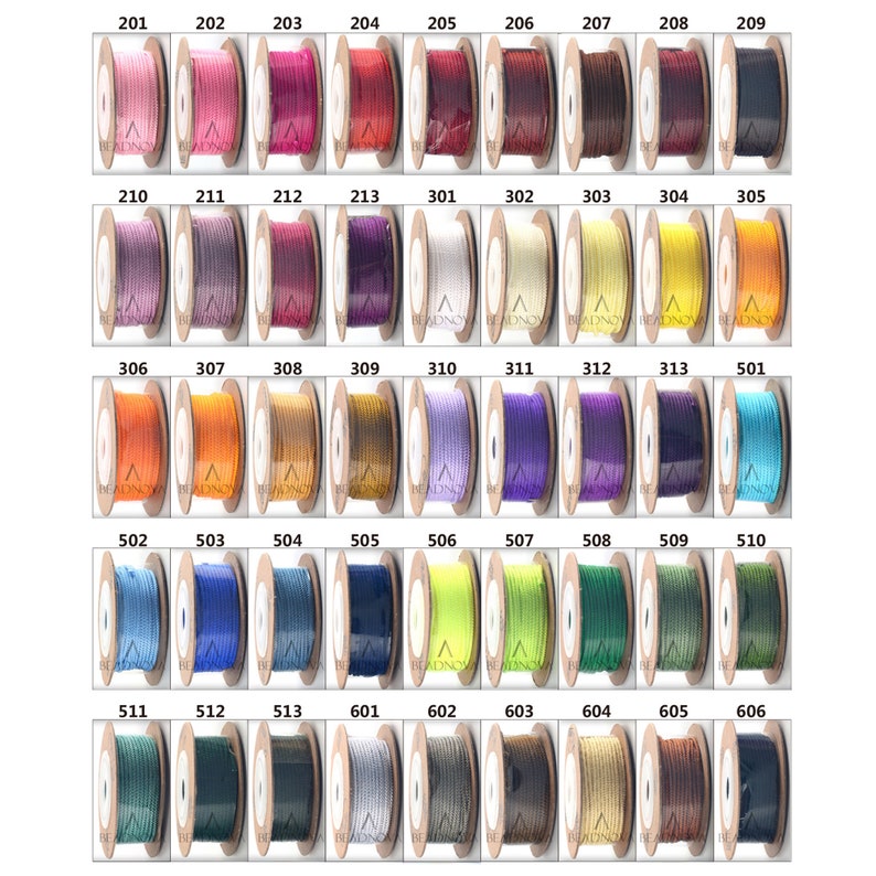 Puede incluir: Una colecci&oacute;n de carretes de hilo de varios colores, numerados del 201 al 606. Los carretes est&aacute;n dispuestos en filas y columnas sobre un fondo blanco.