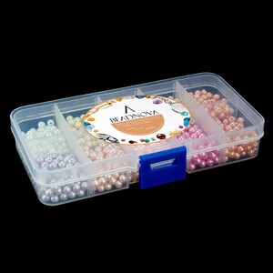May include: A clear plastic organizer box filled with various colors of round beads. The beads are in shades of white, lavender, pink, and peach. The box has a blue clasp and a label that reads "BEADNOVA".