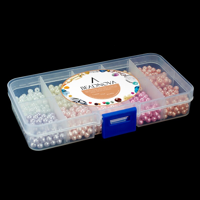 May include: A clear plastic organizer box filled with various colors of round beads. The beads are in shades of white, lavender, pink, and peach. The box has a blue clasp and a label that reads "BEADNOVA".