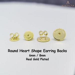 Può includere: Tre dorsi per orecchini placcati in oro in diverse dimensioni. I dorsi sono rotondi con un anello a forma di cuore sul retro. I dorsi sono etichettati "fashion".