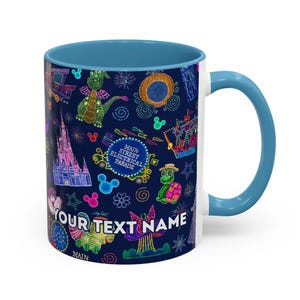 May include: A ceramic mug with a blue interior and handle, featuring a colorful design of the Main Street Electrical Parade. The design includes a castle, a dragon, and the text "YOUR TEXT NAME".