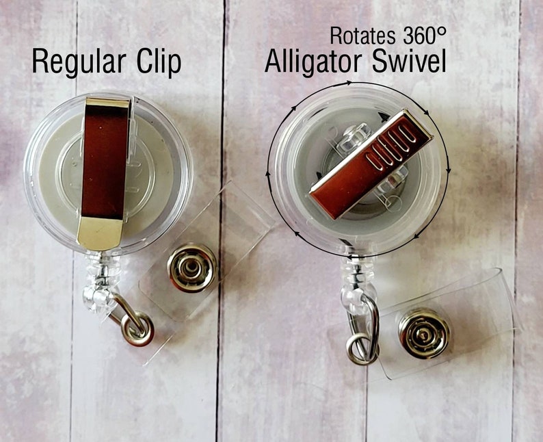 May include: Two clear retractable badge holders with different clips. The left holder has a regular clip. The right holder has a swivel alligator clip that rotates 360 degrees. Both holders have a clear plastic body and a silver metal clip.