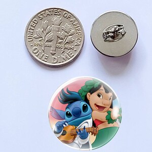 Puede incluir: Un bot&oacute;n con los personajes Stitch y Lilo de la pel&iacute;cula de Disney Lilo & Stitch. El bot&oacute;n tiene un dise&ntilde;o colorido con Stitch tocando el ukelele. Tambi&eacute;n se muestra una moneda de plata y un reverso de bot&oacute;n.