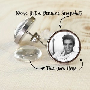 Puede incluir: Pendientes de bot&oacute;n plateados con una imagen en blanco y negro de Elvis Presley. Los pendientes tienen un respaldo transparente y redondeado. El texto "We've got a genuine Snapshot" est&aacute; encima y "This goes Here" debajo.