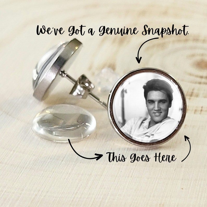 Puede incluir: Pendientes de bot&oacute;n plateados con una imagen en blanco y negro de Elvis Presley. Los pendientes tienen un respaldo transparente y redondeado. El texto "We've got a genuine Snapshot" est&aacute; encima y "This goes Here" debajo.