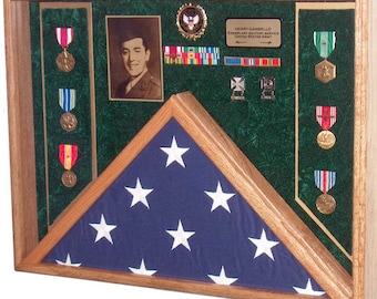 May include: A wooden shadow box with a folded American flag, a framed photo of a man in military uniform, and a collection of medals and ribbons. The text on the plaque reads "Henry Gambello, Exemplary Military Service, United States Army".
