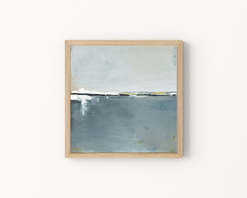 May include: Abstract landscape painting in a natural wood frame. The artwork features a horizon line with white, yellow, and green accents, above a muted blue-gray expanse. The painting evokes a sense of calm and serenity.