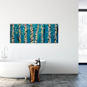 May include: Abstract painting of a forest scene with teal, yellow, white, and black colors. The painting is hanging on a white wall in a bathroom setting.