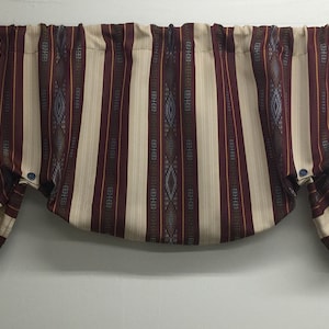 May include: A valance with a striped pattern in shades of brown, cream, and blue. The valance has a gathered look and is made of a woven fabric.