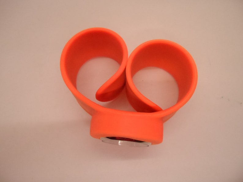 May include: Orange silicone watch band with a silver watch face.
