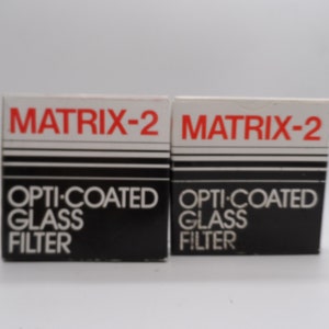 May include: Two black and white boxes with red text that reads "MATRIX-2 OPTI-COATED GLASS FILTER".