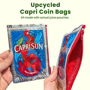May include: A rectangular coin bag crafted from a silver and blue Capri Sun Wild Cherry juice pouch. The front features red cherry graphics and the text Capri Sun Wild Cherry. It includes a red zipper closure and white stitched edges.