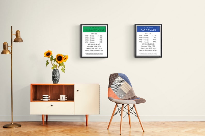 May include: Two framed Monopoly property cards, one for "Park Place" with a blue background and one for "Pennsylvania Avenue" with a green background. The cards list the rent prices for each property with and without houses and hotels.