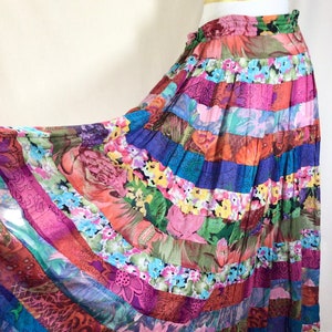May include: A long, colorful patchwork skirt with a floral print. The skirt is made of multiple strips of fabric sewn together, creating a unique and eye-catching design.