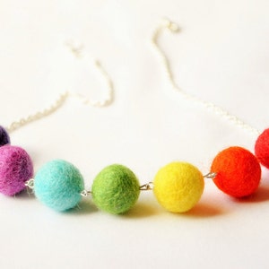 Puede incluir: Un collar de bolas de fieltro de colores arco&iacute;ris con una cadena plateada. Las bolas son moradas, rosas, turquesas, verdes, amarillas, naranjas y rojas.