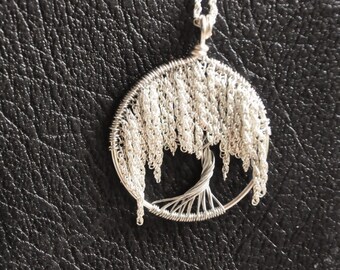 Puede incluir: Collar con colgante de árbol de la vida de alambre plateado con un diseño de sauce llorón. El colgante es redondo y tiene un diseño de alambre detallado.