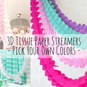 Op de afbeelding: Een close-up van een 3D-weefselpapier streamer-slinger in roze, lichtblauw en wit. De slinger hangt aan het plafond en is gemaakt van weefselpapier dat in kleine vierkanten is geknipt en vervolgens gevouwen om een 3D-effect te creëren. De tekst "3D Tissue Paper Streamers - Pick Your Own Colors -" wordt weergegeven op de afbeelding.