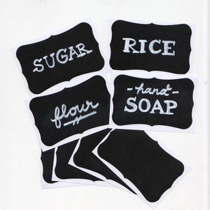Pode incluir: Etiquetas de quadro-negro pretas e brancas com texto branco. As etiquetas dizem "Açúcar", "Arroz", "Farinha" e "Sabonete para as mãos".