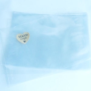 Puede incluir: Una bolsa de pl&aacute;stico transparente con una peque&ntilde;a etiqueta de madera en forma de coraz&oacute;n que dice "HAND made".
