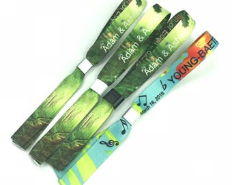 May include: Four colorful wristbands with different designs. The wristbands are made of fabric and have a plastic clasp. The wristbands have the text "Adam & Ashley" and "YOUNG-BAE" printed on them. The wristbands are a popular accessory for events and festivals.