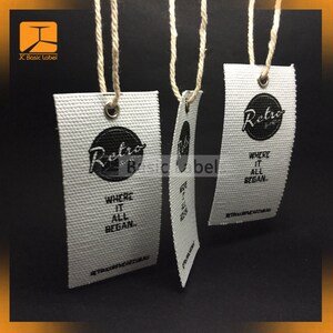 Puede incluir: Tres etiquetas de tela blanca con texto negro y un logotipo circular negro que dice "Retro" con una peque&ntilde;a "B" dentro del c&iacute;rculo. El texto en las etiquetas dice "Where it all began." y "retrosurfwear.com.au".