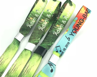 May include: Three colorful wristbands with different designs. The first two wristbands have a green background with a nature scene and the text "Adam & Ashley". The third wristband has a blue background with musical notes and the text "YOUNG-BAE" and "March 18, 2018".