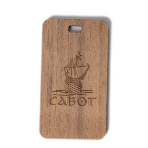 May include: A wooden luggage tag with a laser-engraved image of a ship and the word "CABOT".
