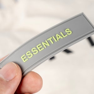 May include: A gray label with the word "ESSENTIALS" printed in yellow.