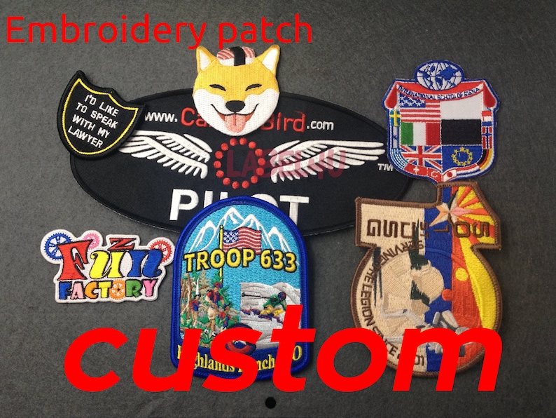 May include: A selection of embroidered patches featuring various designs, including a dog, pilot's wings, a troop logo, a factory logo, and a flag with multiple countries. The patches are on a grey background with the word "custom" written in red.