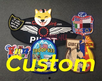 May include: A collection of colourful embroidered patches with various designs, including a dog, a plane, a troop logo, and a flag. The patches are arranged on a grey surface with the word "Custom" written in yellow letters.