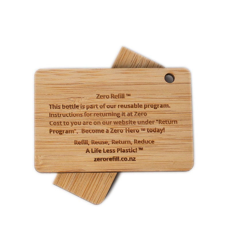 May include: A wooden tag with the text "Zero Refill" and instructions for returning a reusable bottle. The tag says "This bottle is part of our reusable program. Instructions for returning it at Zero Cost to you are on our website under "Return Program". Become a Zero Hero today! Refill, Reuse, Return, Reduce A Life Less Plastic! zerorefill.co.nz"