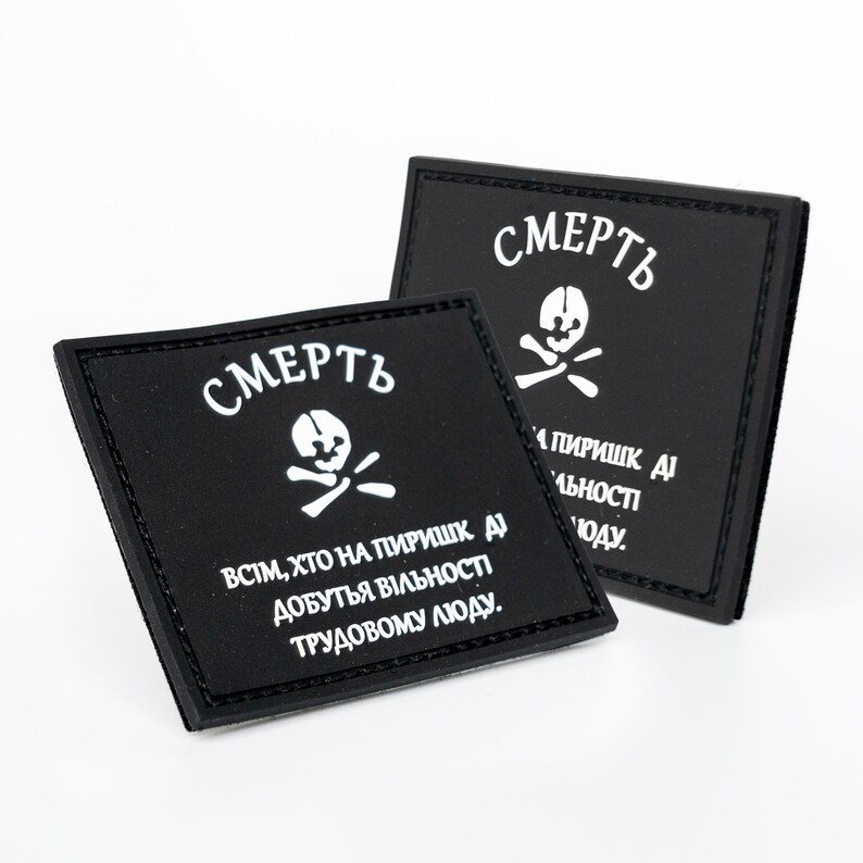 May include: Two black square patches with white text and a skull and crossbones symbol. The patches have the word "СМЕРТЬ" at the top and additional text below. The patches are on a white background.