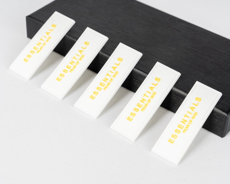 May include: Five white rectangular labels with the text "ESSENTIALS FEAR OF GOD" printed in gold letters.