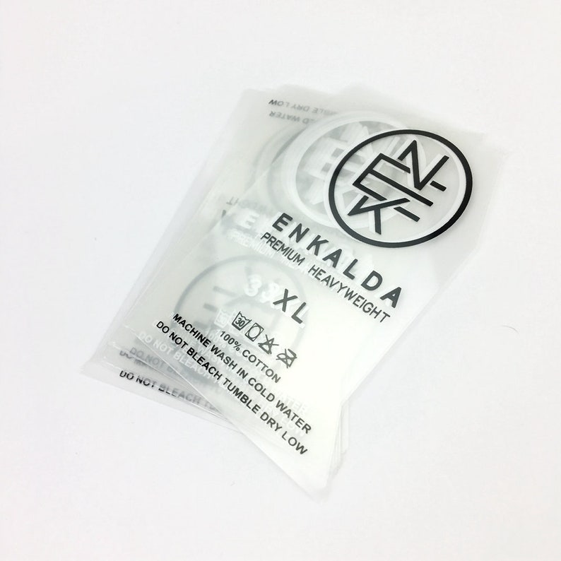 May include: White plastic packaging with a white label that says "ENKALDA PREMIUM HEAVYWEIGHT 3XL". The label also includes care instructions: "100% COTTON, MACHINE WASH IN COLD WATER, DO NOT BLEACH, TUMBLE DRY LOW".