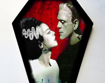 May include: A painting of Frankenstein's monster and his bride, with a red background and the text "@Lalas Art" in the bottom right corner.