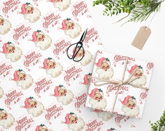 Puede incluir: Papel de regalo blanco con un patrón repetido de Papá Noel con un gorro rosa y el texto "¡Feliz Navidad a todos!" en rojo.