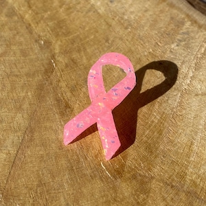 Peut inclure: Ruban rose avec des paillettes, symbole de la sensibilisation au cancer du sein.