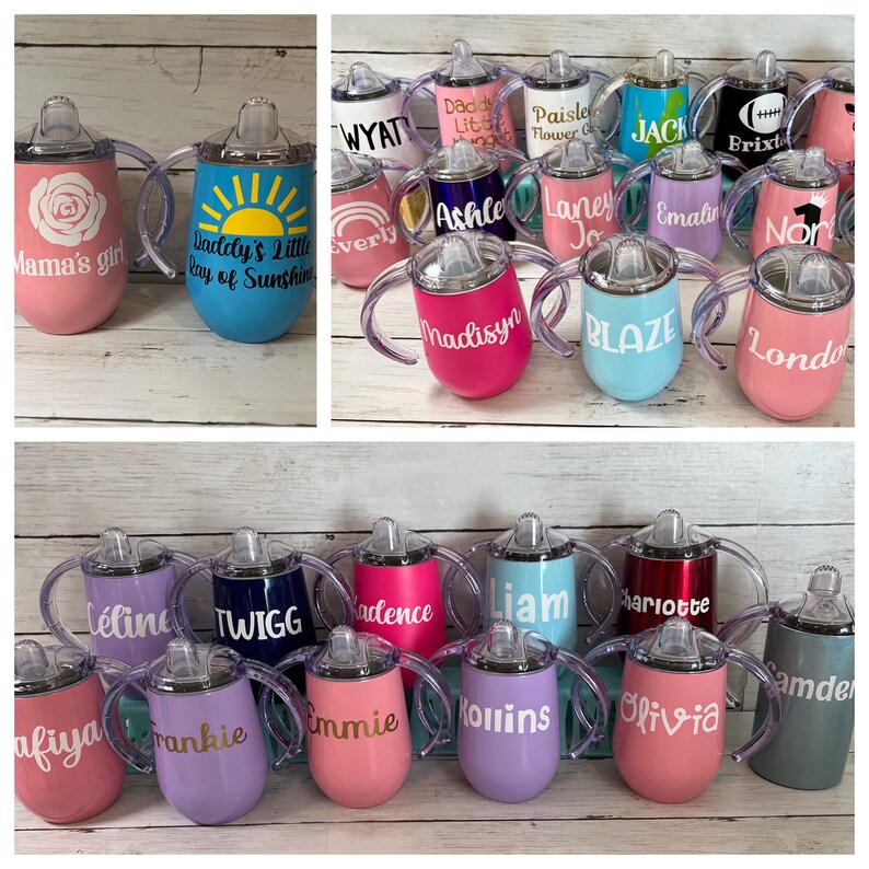 May include: A collection of 20 personalized stainless steel sippy cups with various colors and designs. The cups have two handles and a straw lid. Some of the names on the cups include: Wyatt, Daddy's Little, Paisley Flower Girl, Jack, Brixto, Mama's Girl, Daddy's Little Ray of Sunshine, Everly, Ashle, Laney Jo, Emalin, Nor, Madisyn, Blaze, London, Celine, Twigg, Kadence, Liam, Charlotte, Samde, Afiyaa, Frankie, Emmie, Kollins, Olivia.