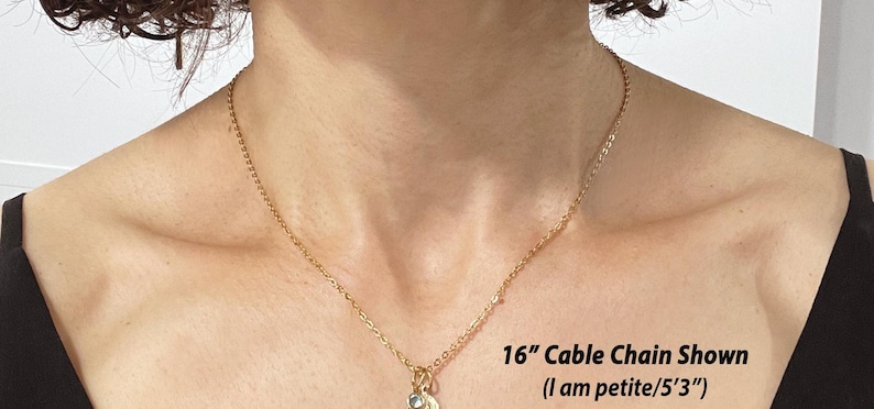 May include: A 16-inch gold cable chain necklace on a person's chest. The text "16" Cable Chain Shown (I am petite/5'3")" is below the chain.