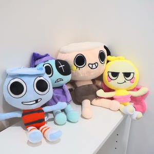 以下が含まれることがあります： 黒い持ち手と「But First, Coffee」の太字の黒い文字が入った白いセラミックマグ。マグカップはぼやけた背景に置かれており、居心地の良い環境を示唆しています。