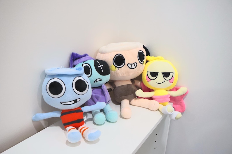 以下が含まれることがあります： 黒い持ち手と「But First, Coffee」の太字の黒い文字が入った白いセラミックマグ。マグカップはぼやけた背景に置かれており、居心地の良い環境を示唆しています。