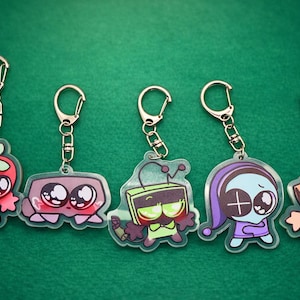 May include: A white ceramic mug with a black handle and the text "But First, Coffee" in a bold, black font. The mug is set against a blurred background, suggesting a cozy setting.